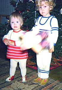 Sara i r�tstickad kl�nning och hennes storebror i matchande h�ngslrbyxor och jumper.