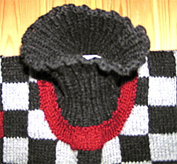 Dealjbild av halsringningen p� Svart och gr�rutig polotr�ja med vinr�da knater och en och annan vinr�d ruta