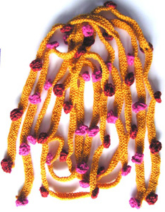 Rtstickade gula smala halsdukar med glest instickade moucher i rosa eller rost.