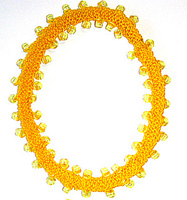 R�tstickat gult halsband med p�rlor.