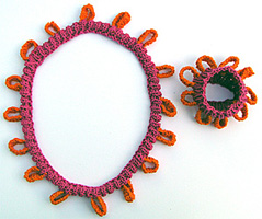 Res�rstickat rosa hals- och armband med ringar.