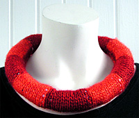 Tv� r�da nyanser i halsbandet fr�n kollektion Rund