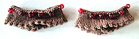 Sltstickade beige ristband med uddkant och rd prlor.