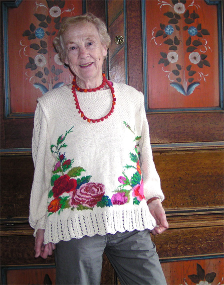 Bomullsjumper med blommor och lng rm. Stickat halsband i matchande frger.