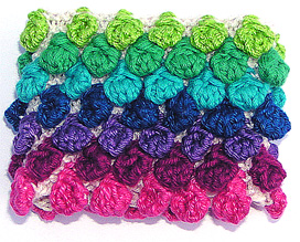 Rtstickat oblekt armband med moucher i olika rosa-lila-bl frger.